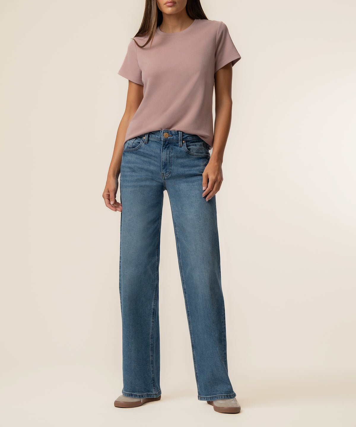 Woman wearing vintage rose short-sleeve t-shirt with blue denim jeans.