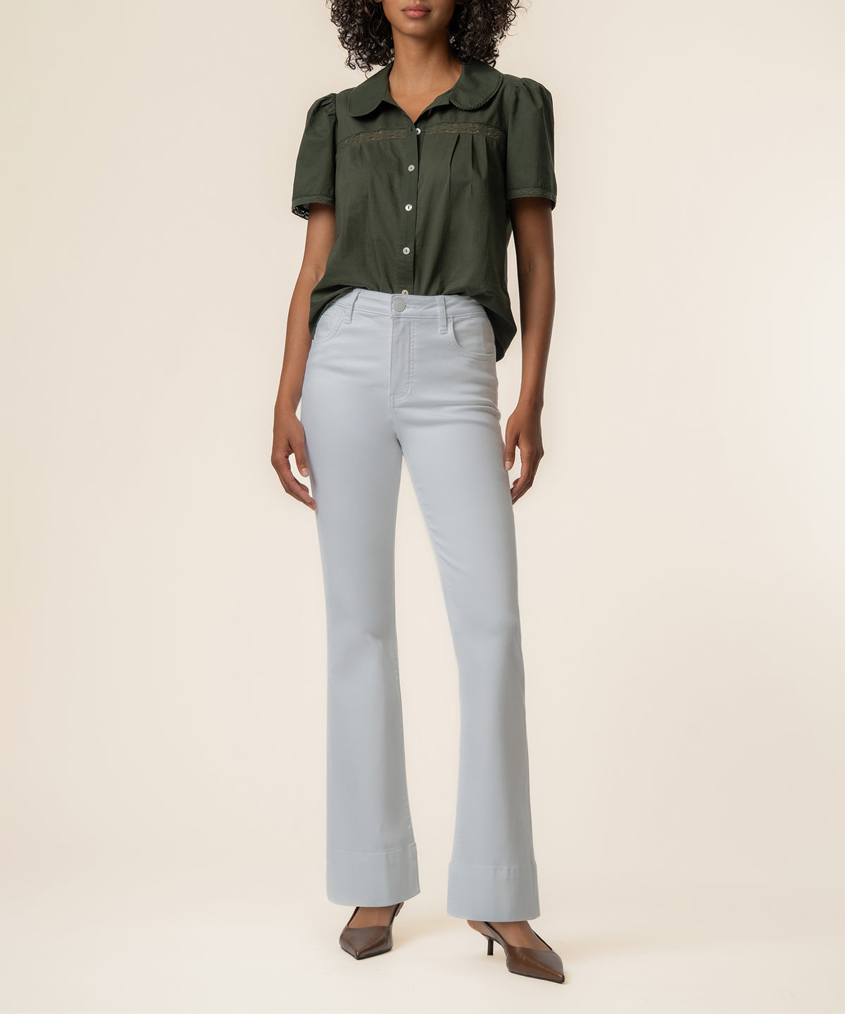 Olive short-sleeve button-front top with collar paired with light blue high-waisted flared jeans.