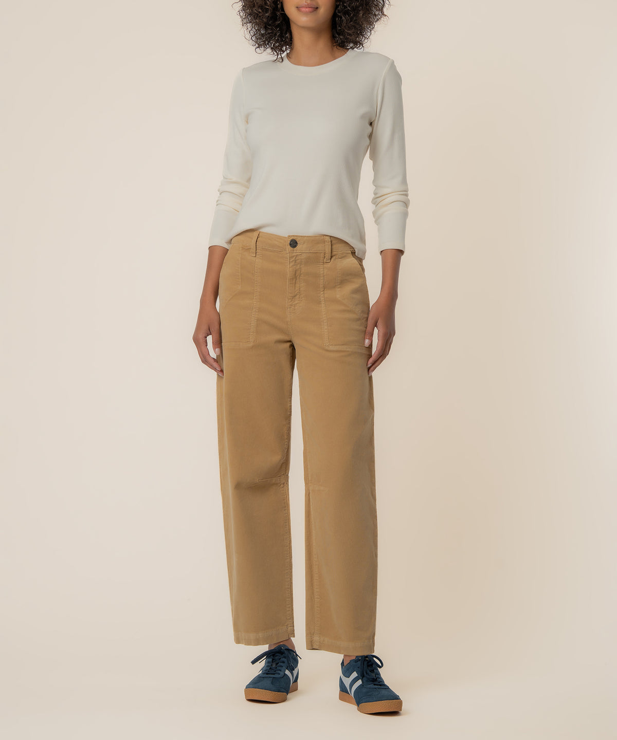 Khaki high-rise barrel corduroy pants with straight legs and visible seams, paired with a cream long-sleeve top.