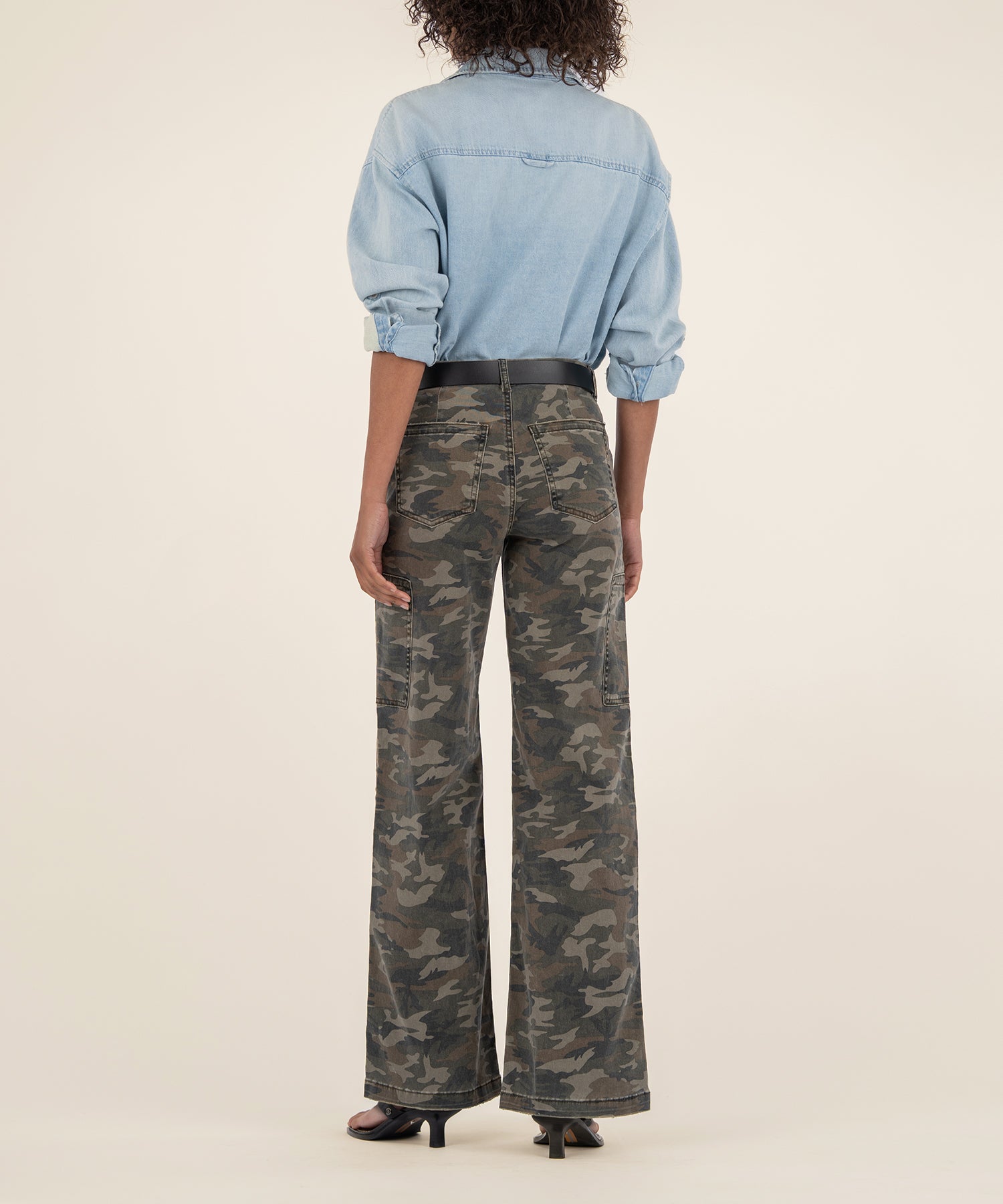 Olive camouflage wide-leg jeans with high rise waistband, shown from back view with light blue denim shirt.
