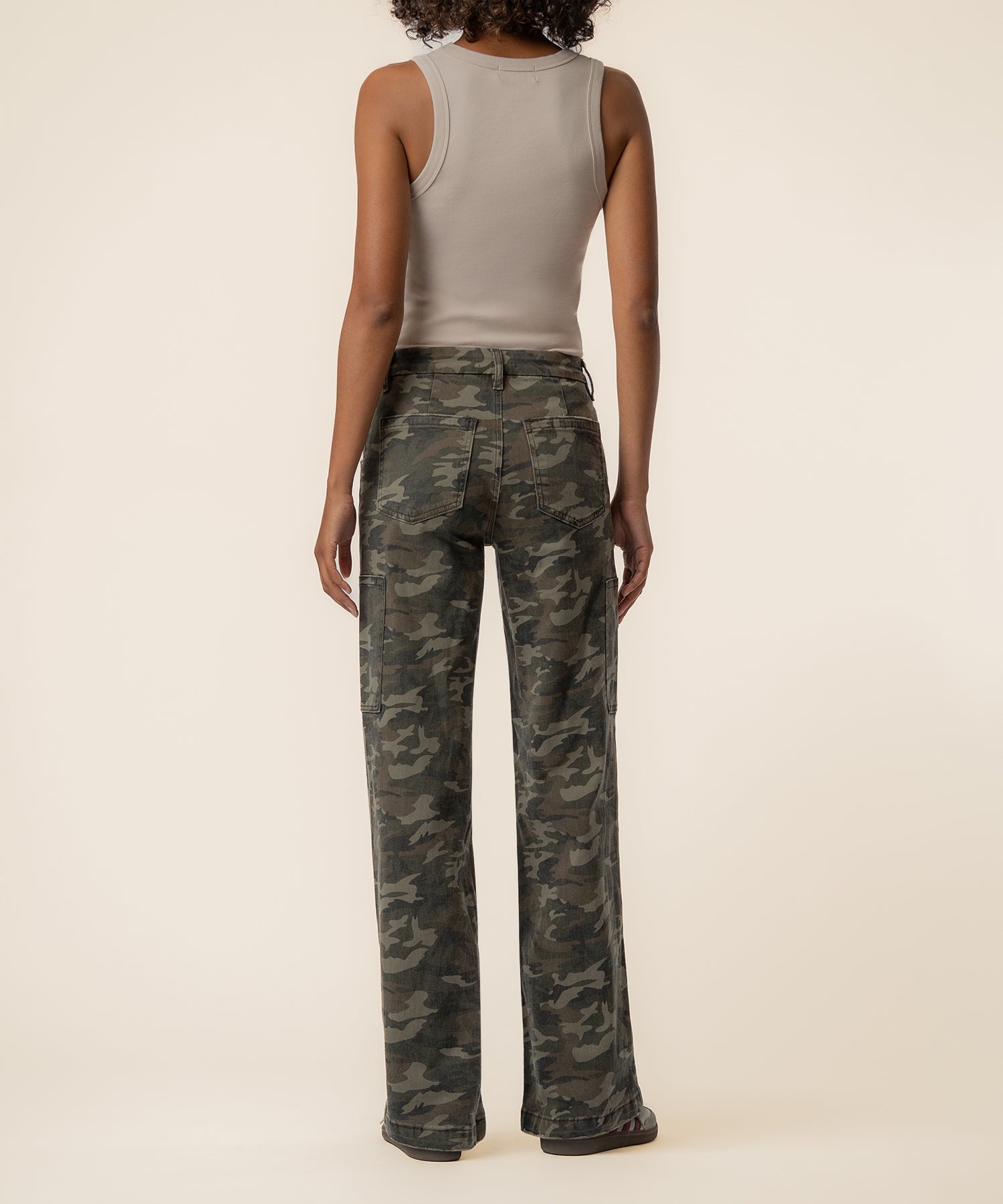 Olive camouflage high-rise wide-leg jeans with straight silhouette, shown from back on model wearing beige tank top.