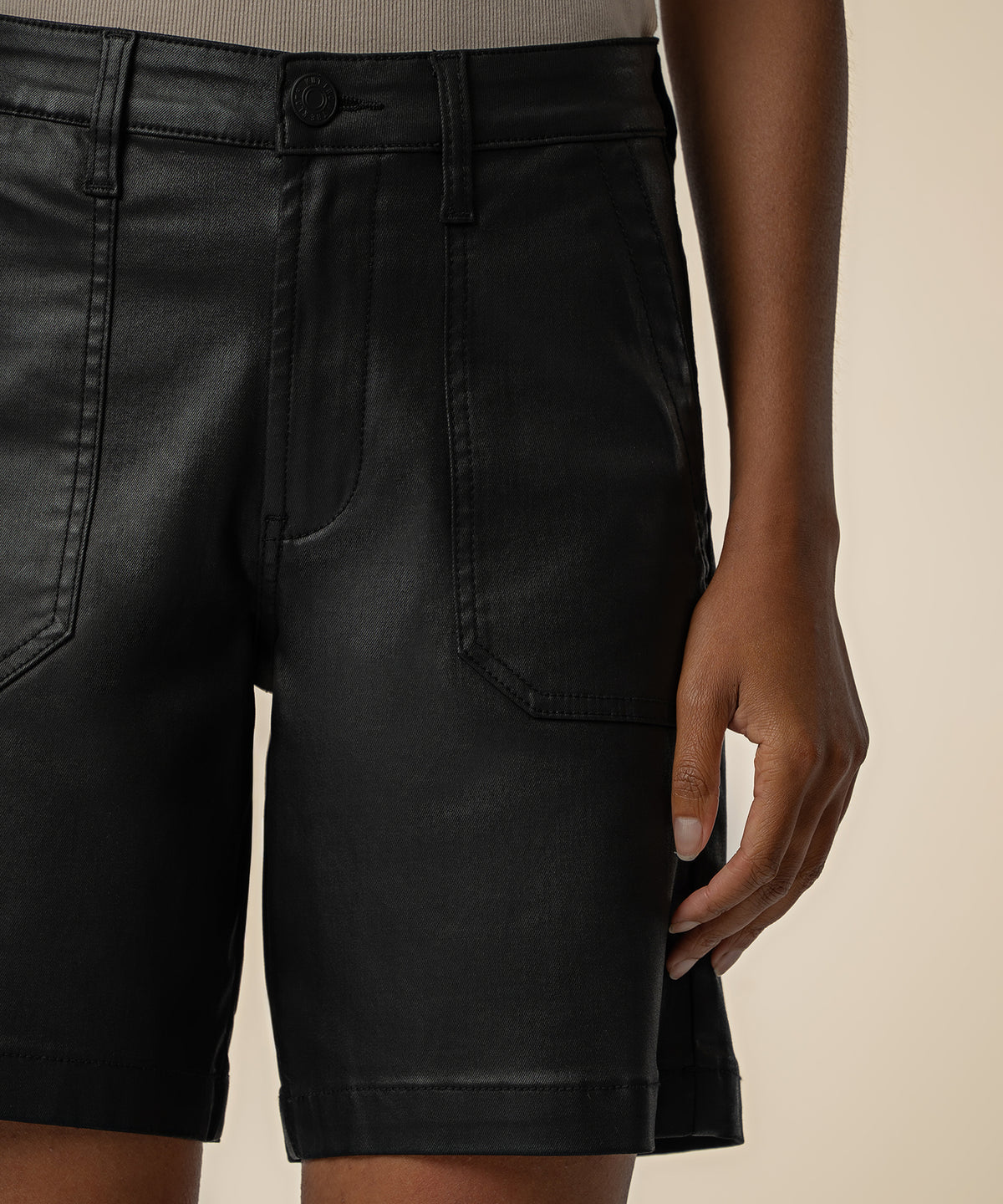 Black coated denim bermuda shorts with high rise waist, button closure, and front pockets.