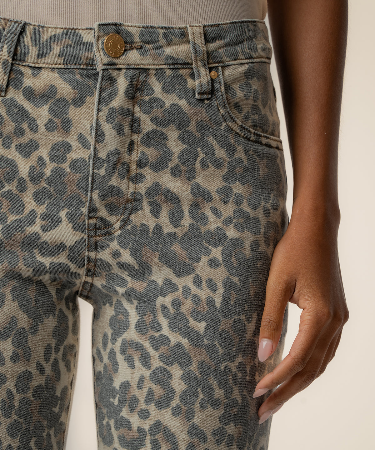 Tan and brown leopard print high-rise flare jeans with gold button and front pocket detail.