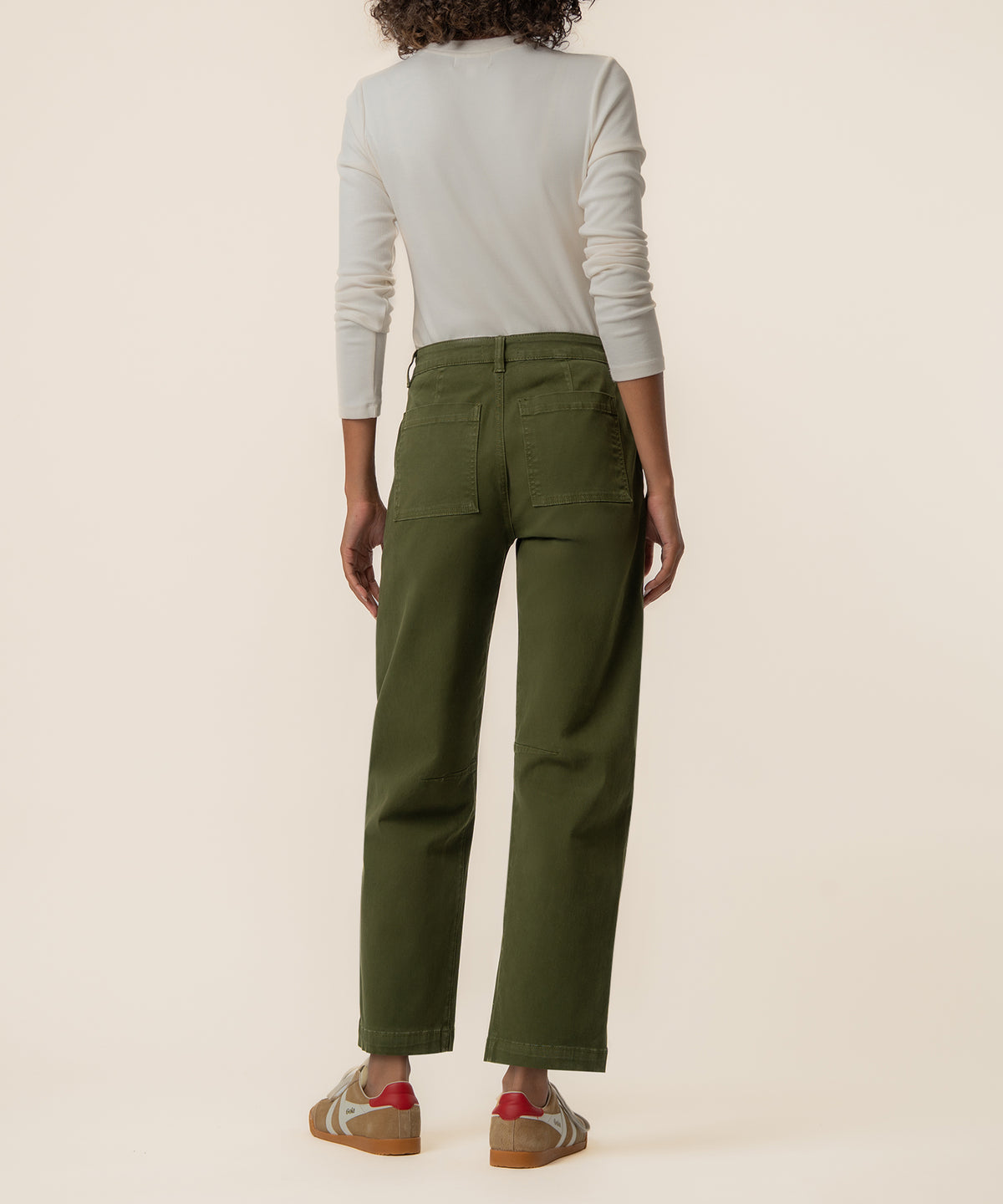 Olive green wide-leg barrel jeans with patch pockets, shown from the back on a model wearing a cream long-sleeve top.