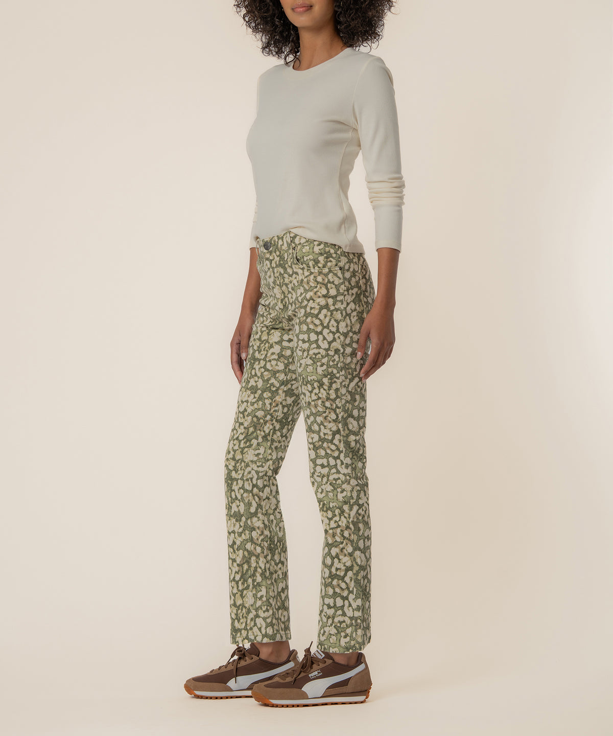 Dark olive ankle flare jeans with leopard print, paired with cream long-sleeve top and brown sneakers.