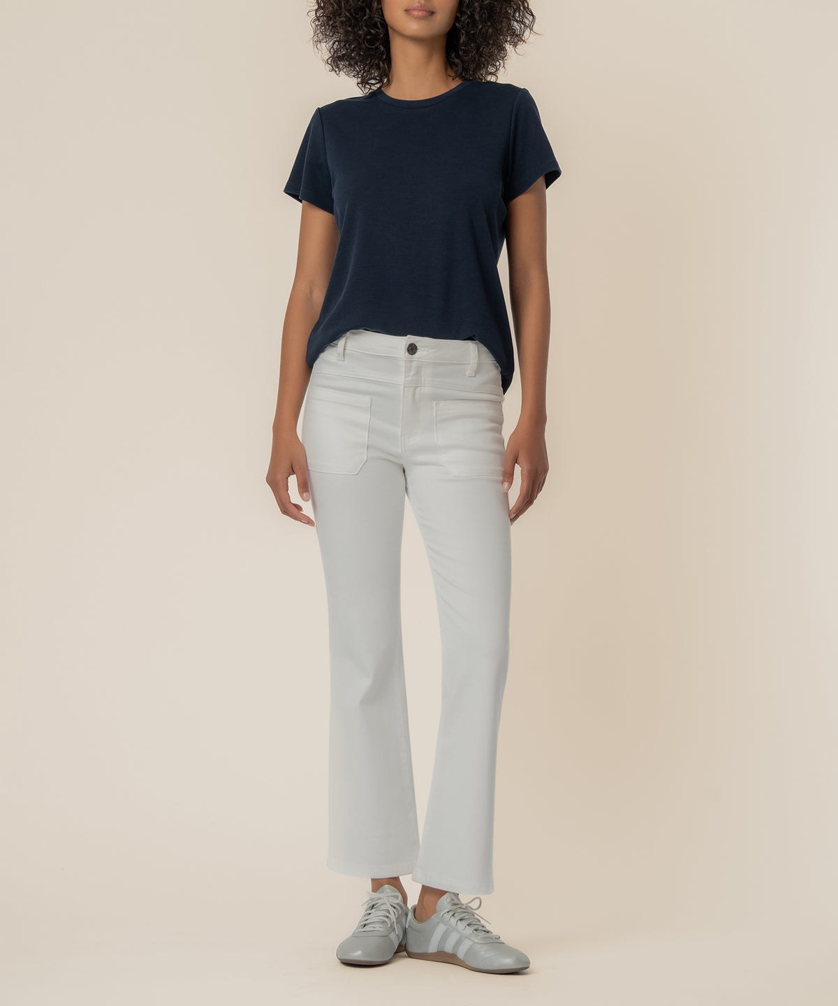 White high-rise flare jeans with front pockets and button waistband, styled with navy short-sleeve t-shirt.