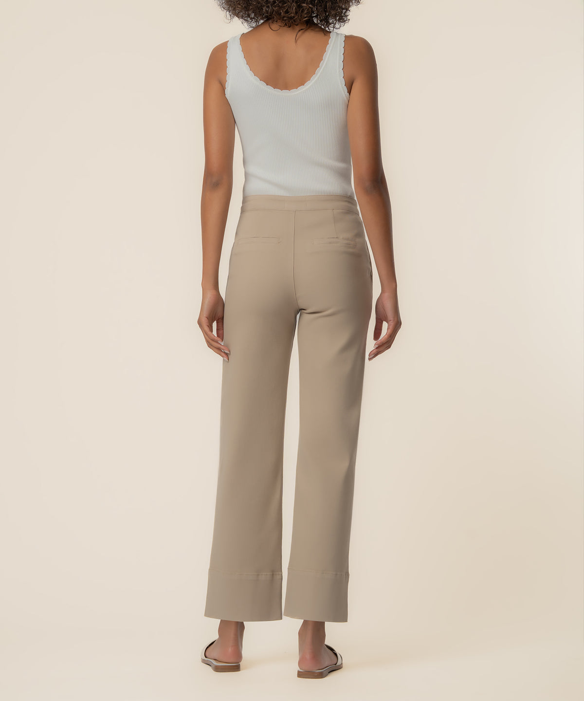 Sand-colored high-rise wide-leg twill pants worn with a white ribbed tank top, shown from back view.