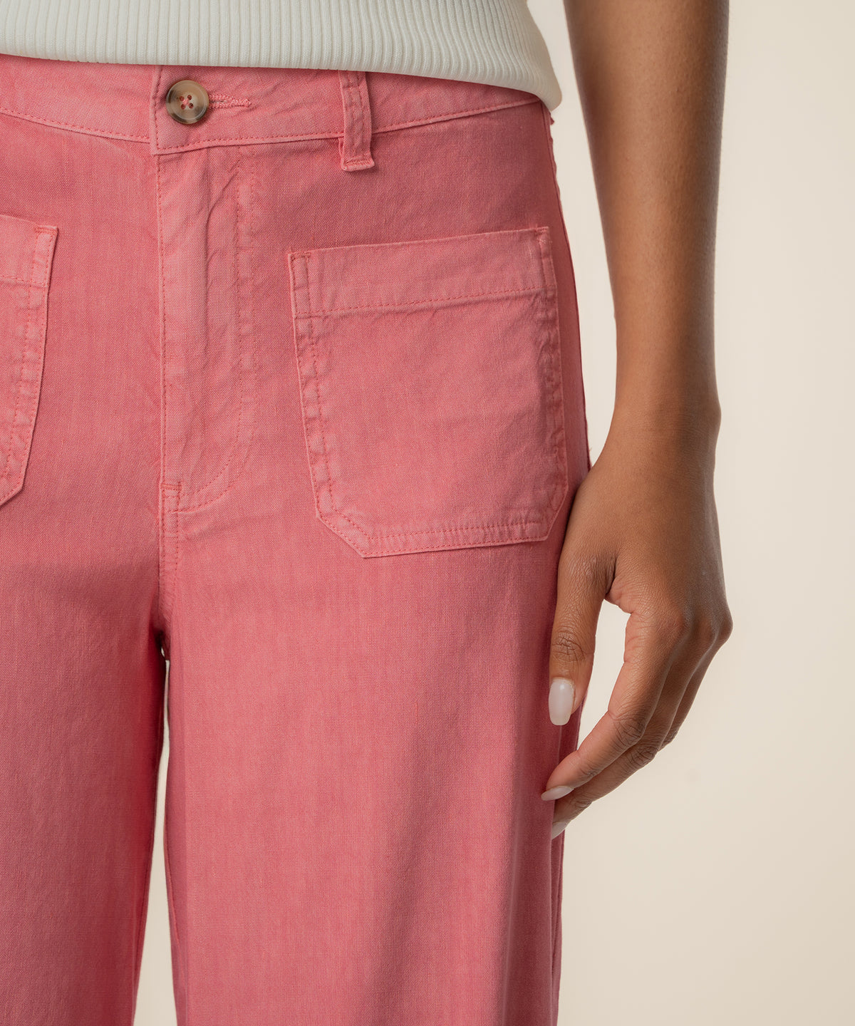 Flamingo pink high-rise wide-leg linen pants with button closure and patch pockets.