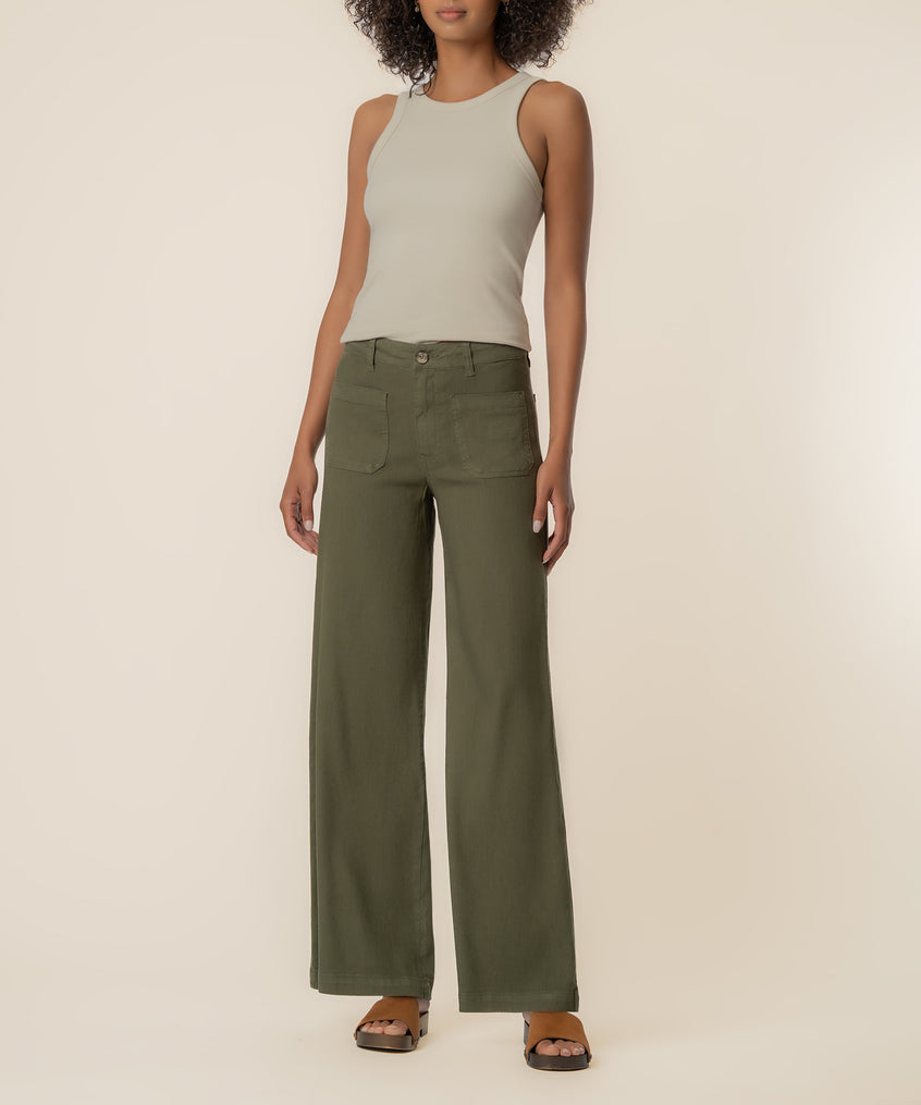 Forest green linen wide-leg pants with high rise waistband and patch pockets, styled with cream tank top.