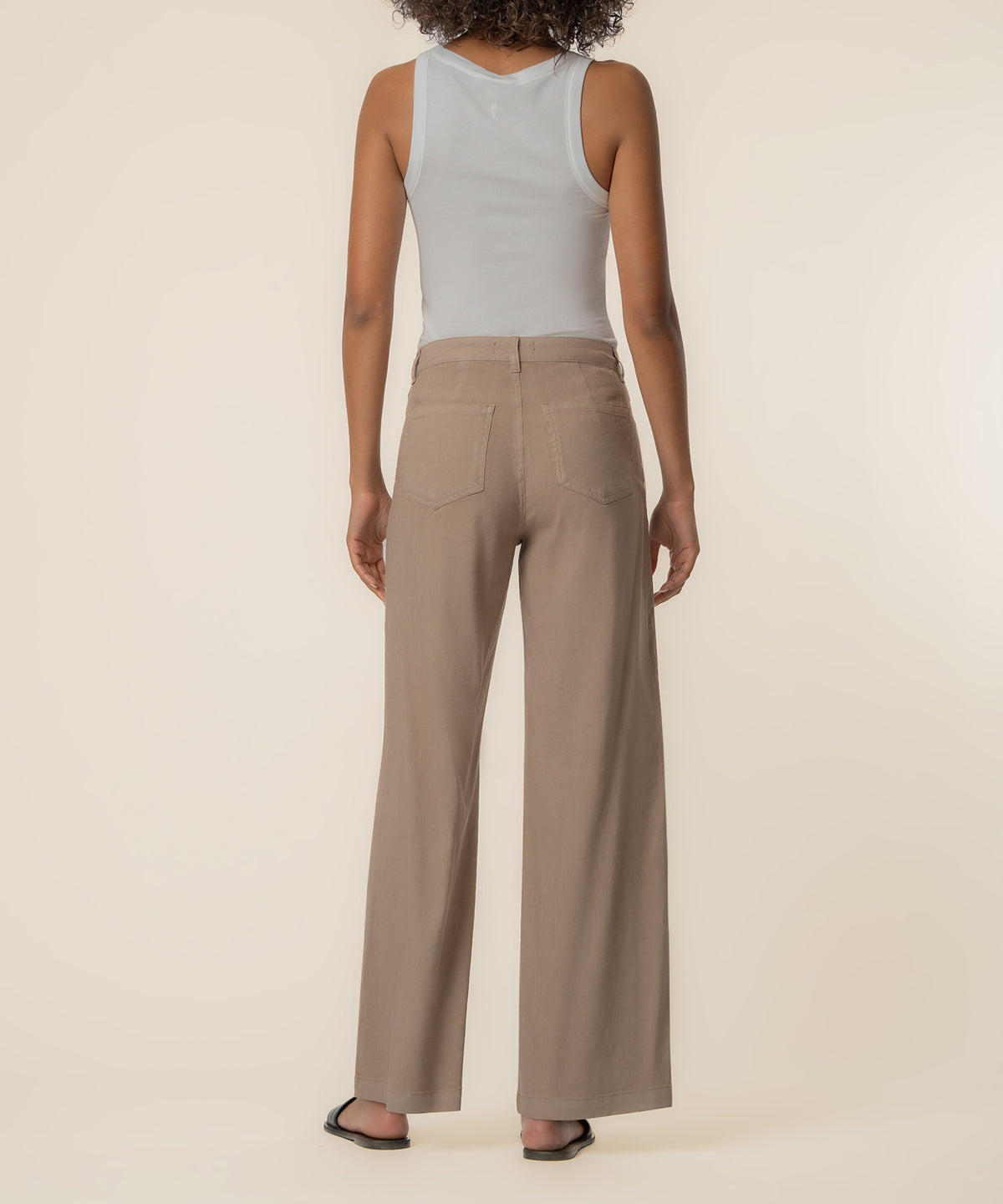 Khaki linen high-rise wide-leg pants with a five-pocket design, shown from the back on a model wearing a white tank top.