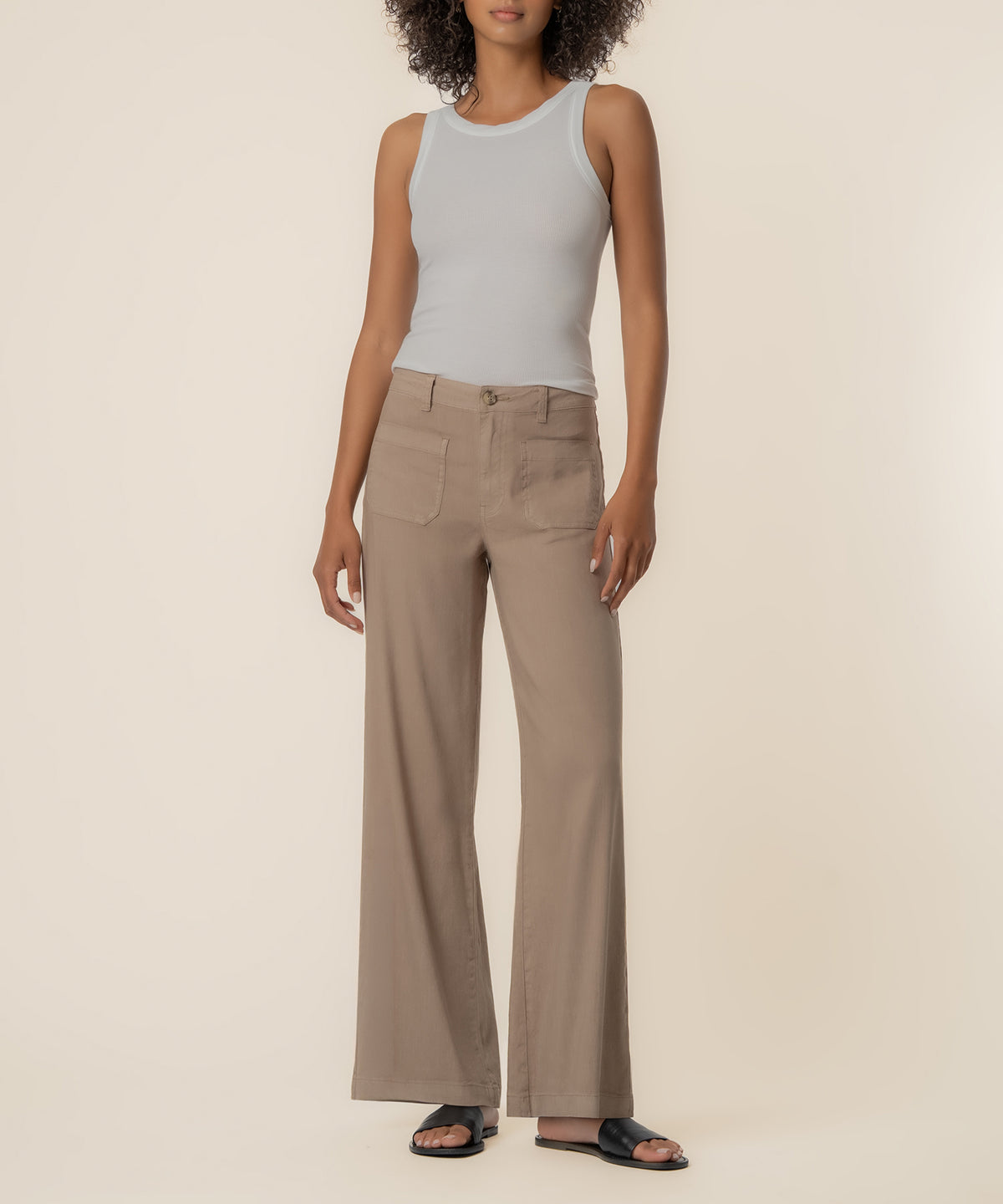 Khaki high-rise wide-leg linen pants with front pockets, shown with white sleeveless tank top and black slides.