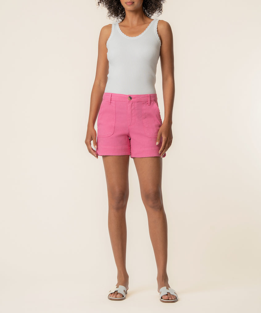 Pink linen high-rise shorts with front pockets on model wearing white tank top.