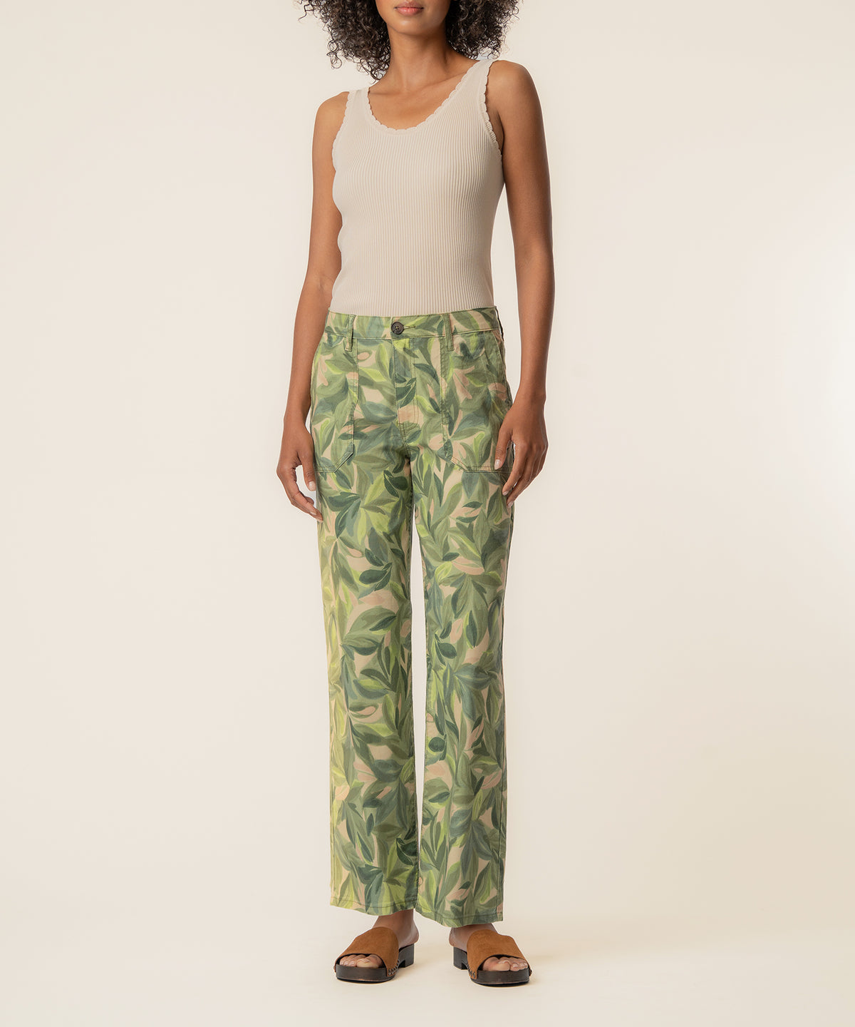 Woman wearing cream ribbed tank top and olive linen straight-leg pants with leafy print pattern.
