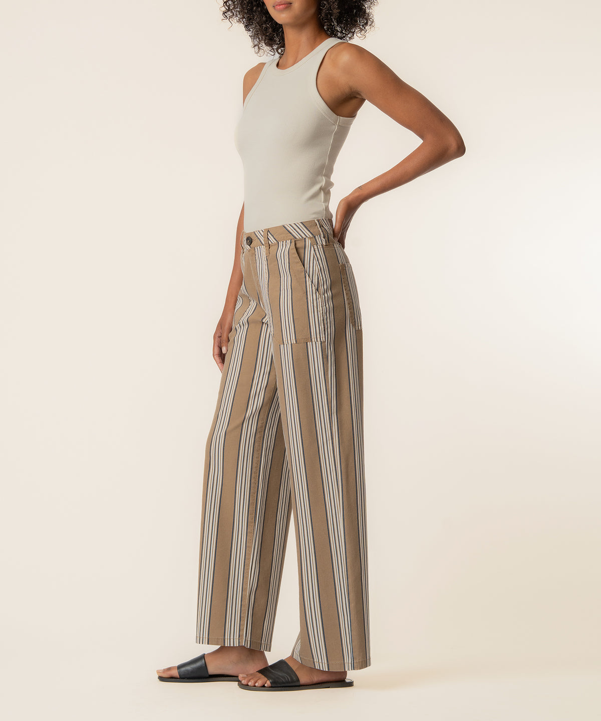 Taupe linen pants with vertical stripes, high waistband, and straight leg silhouette on model.