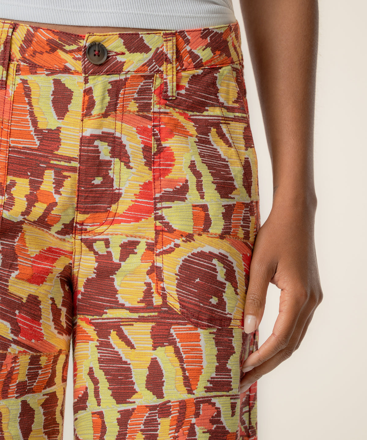 Wine, yellow, and orange abstract patterned linen pants with high waist and straight leg silhouette.