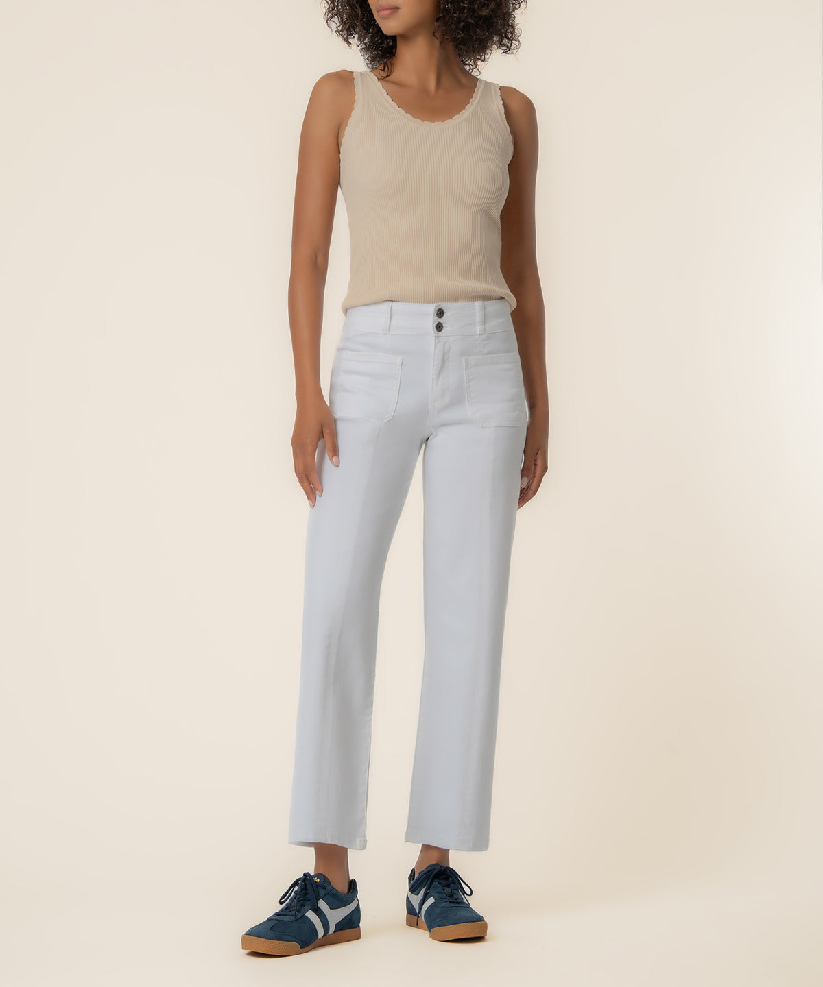 White high-rise straight-leg jeans with button fly and visible pocket stitching, styled with a beige ribbed tank top.