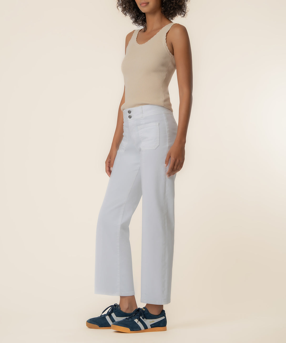 White high-rise straight-leg jeans with button closure and front pockets, paired with a beige ribbed tank top.