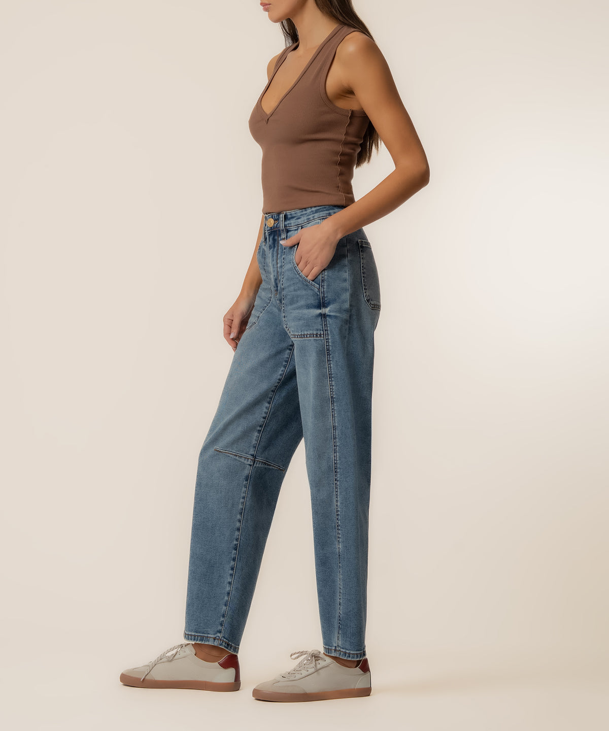Woman wearing high-rise wide-leg barrel jeans in medium blue wash with brown sleeveless top.