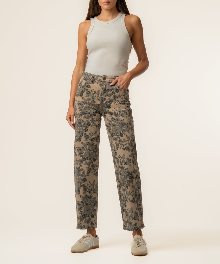 Sand-colored twill pants with dark floral print, high rise and relaxed leg fit, styled with white tank top.