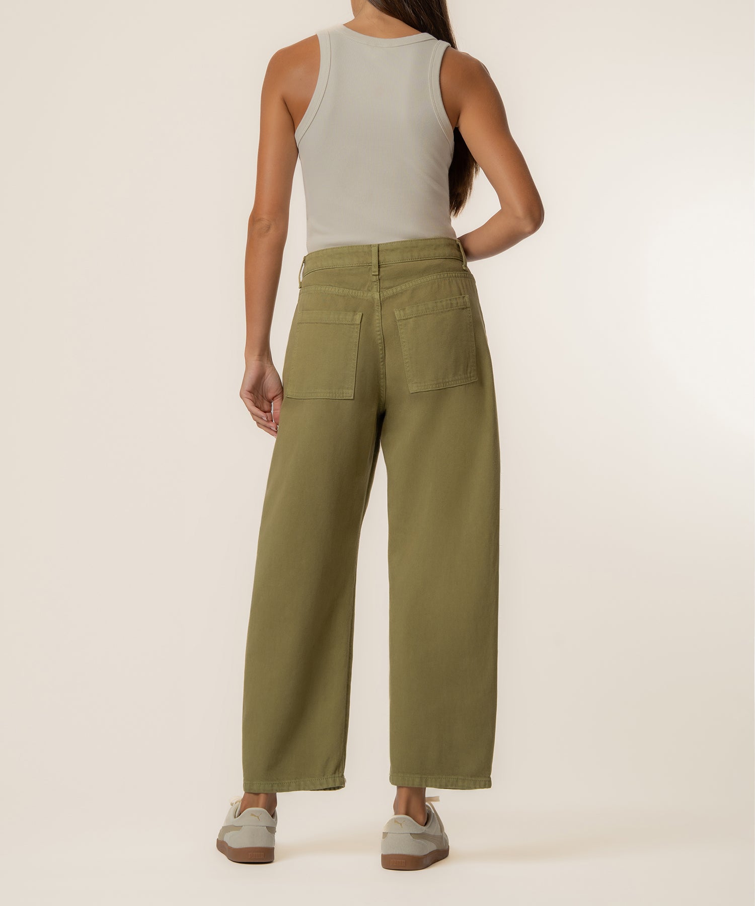 Olive-green high-rise relaxed leg trousers with back pockets, shown on model wearing cream tank top.