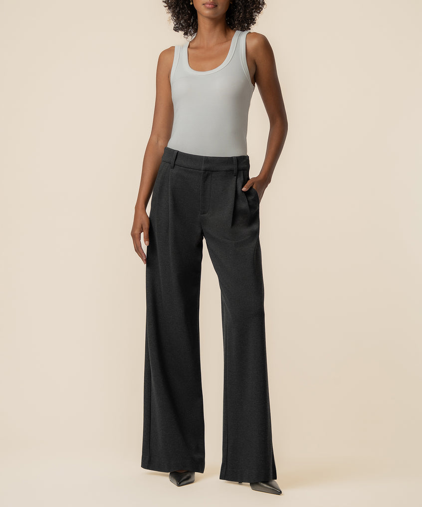 Woman wearing charcoal wide-leg ponte pants with high rise waistband and white sleeveless tank top.