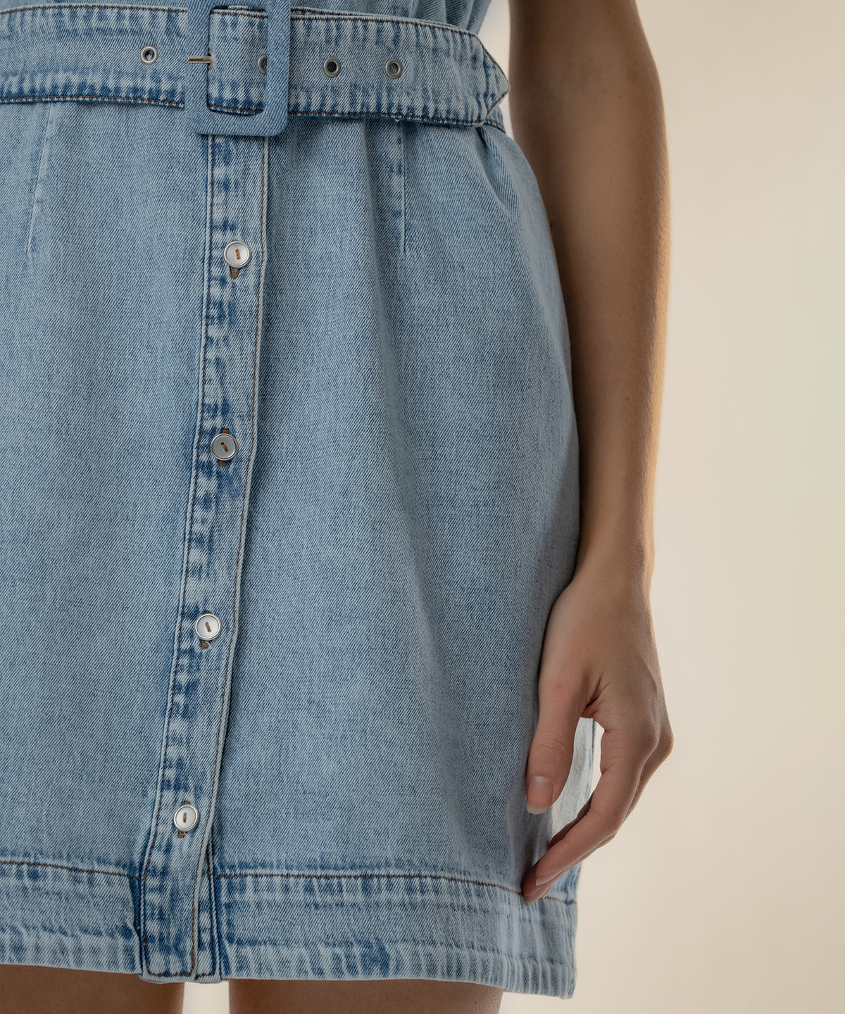 Light blue denim halter dress with button-front closure and belt at waist.