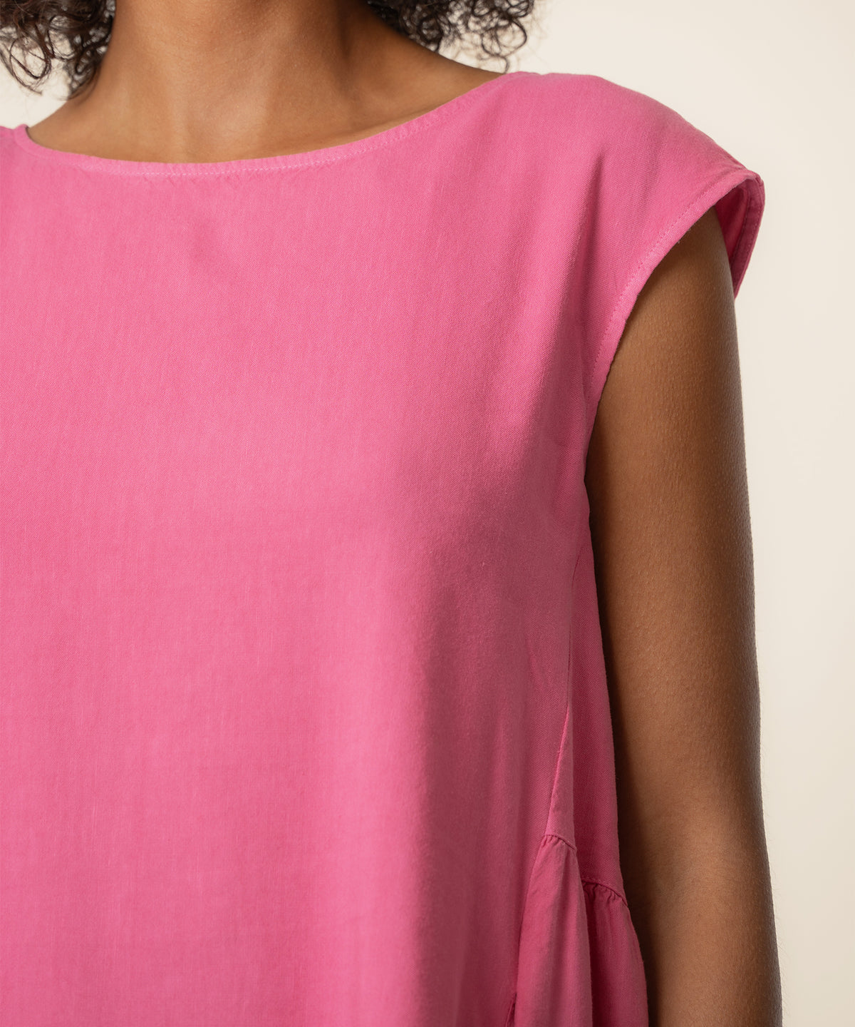 Bright pink linen dress with short cap sleeves and crew neckline on a model.