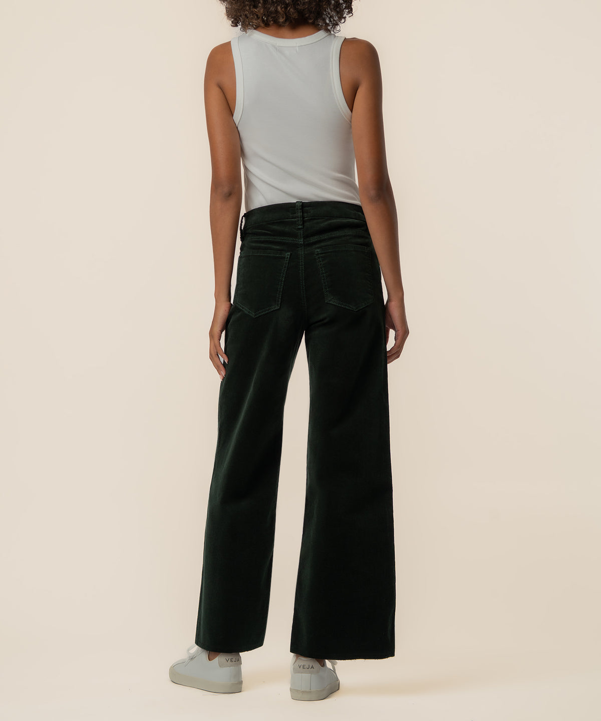 Dark forest corduroy high-rise wide-leg pants shown on model from waist down with white tank top.
