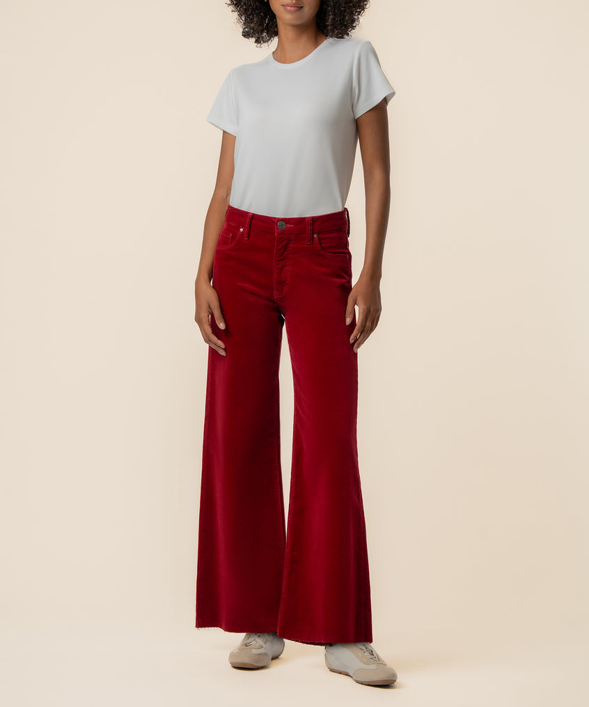 Woman wearing red corduroy high-rise wide-leg pants with a white t-shirt.