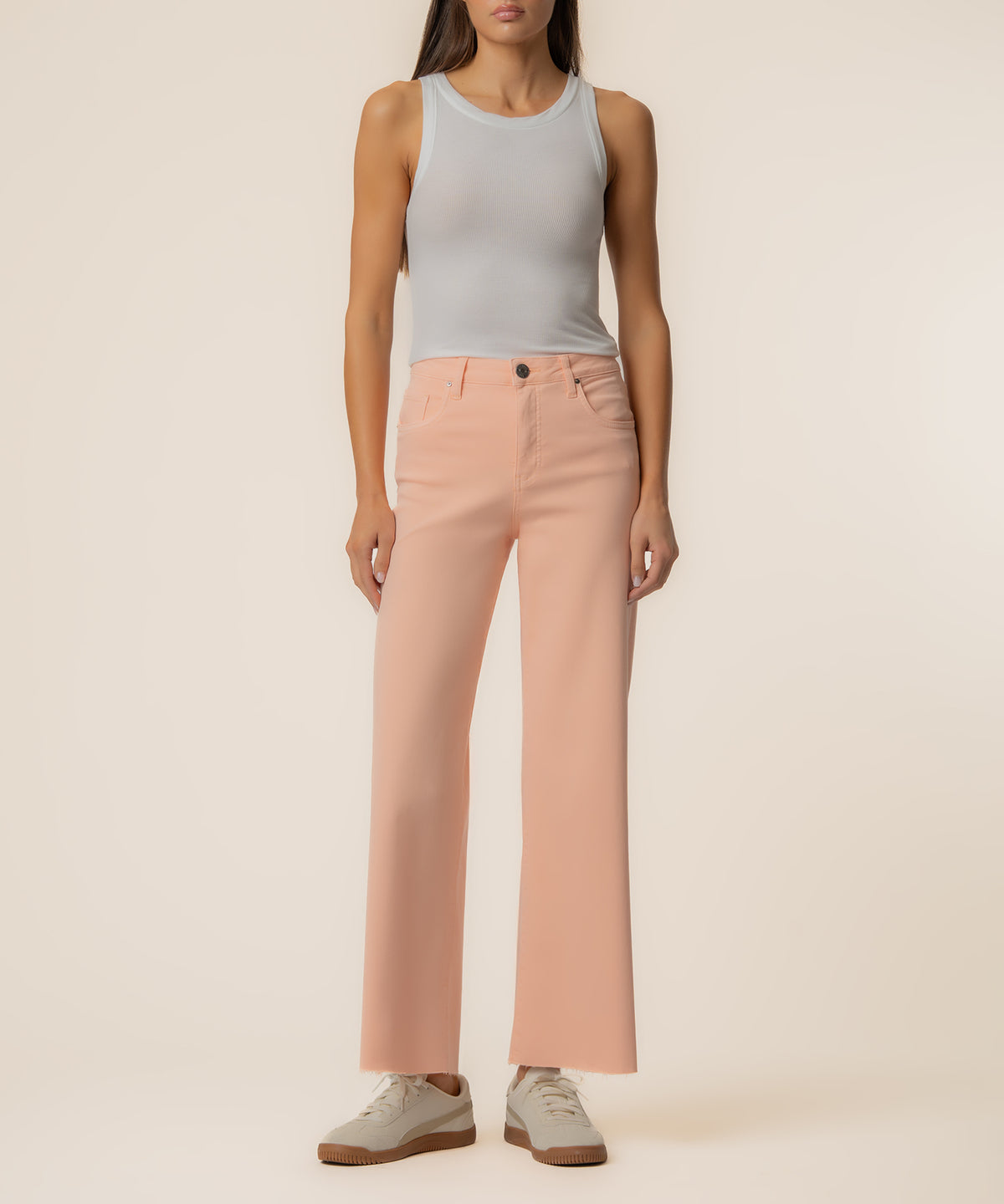 Peach high-rise wide-leg jeans with button closure, paired with gray sleeveless tank top.