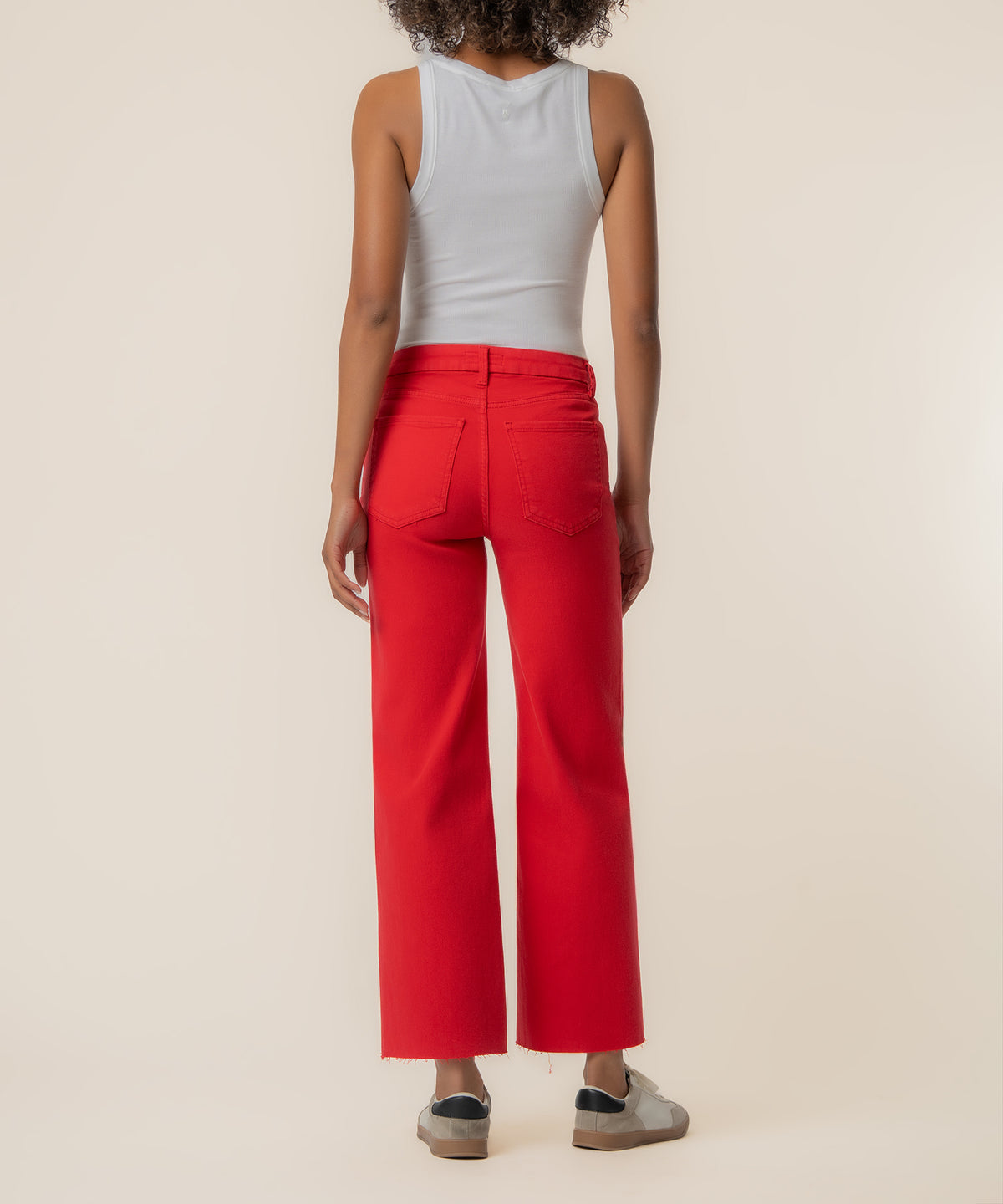 Red high-rise wide-leg jeans with raw hem, shown from back with white tank top.