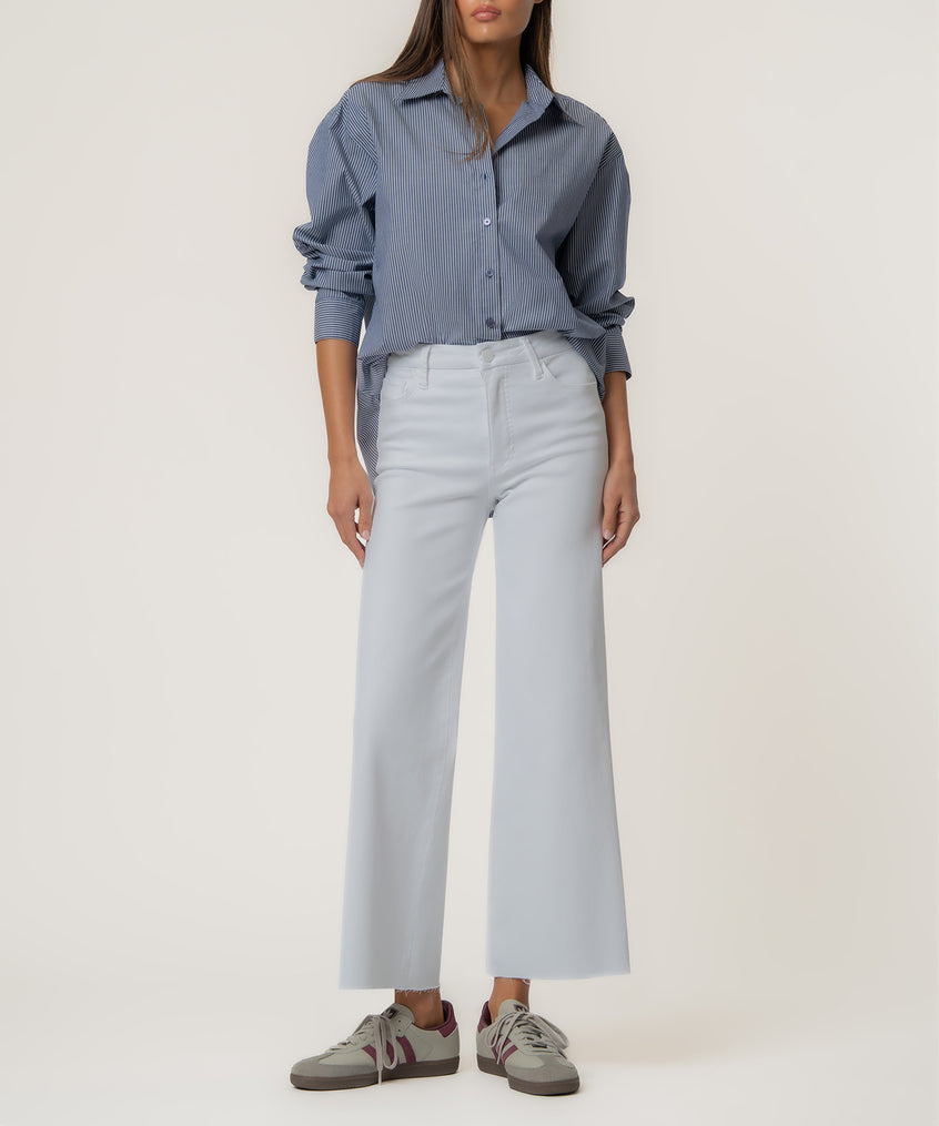 White high-rise wide-leg jeans with a long inseam, paired with a blue striped button-up shirt.