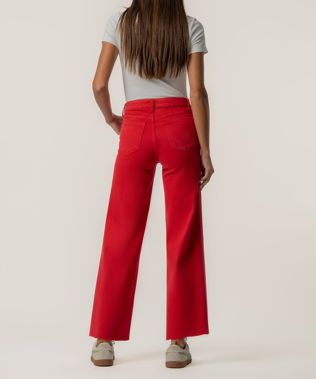 Red high-rise wide-leg jeans with five-pocket styling shown on model from behind.