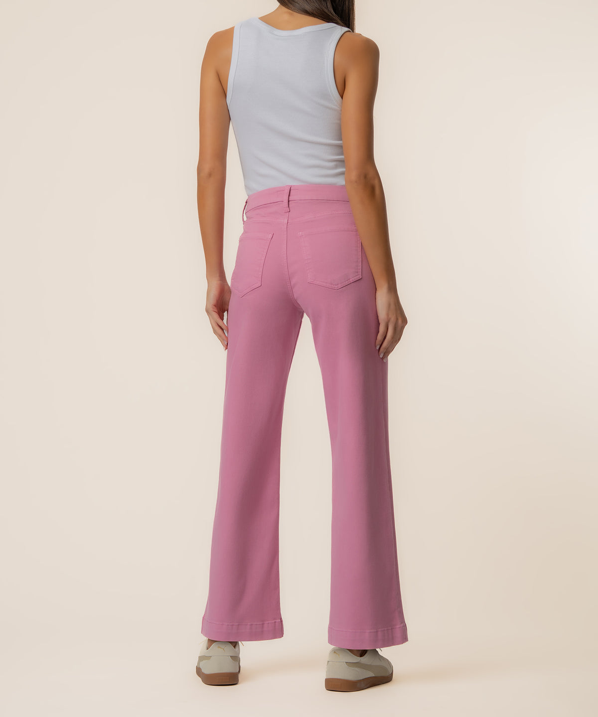 Pink high-rise wide-leg jeans with back pockets, worn with a light blue sleeveless top.
