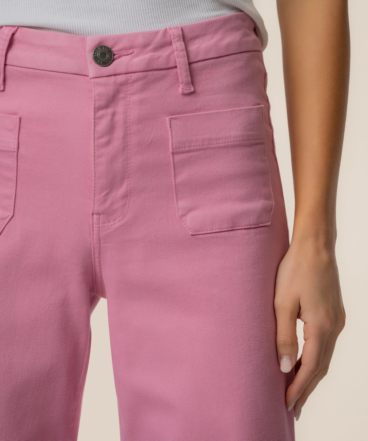 Pink high-rise wide-leg pants with cargo pockets and button closure.