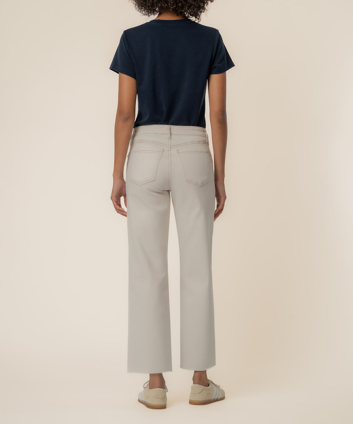 Ecru high-rise wide leg jeans with five-pocket styling, shown from back with navy t-shirt.