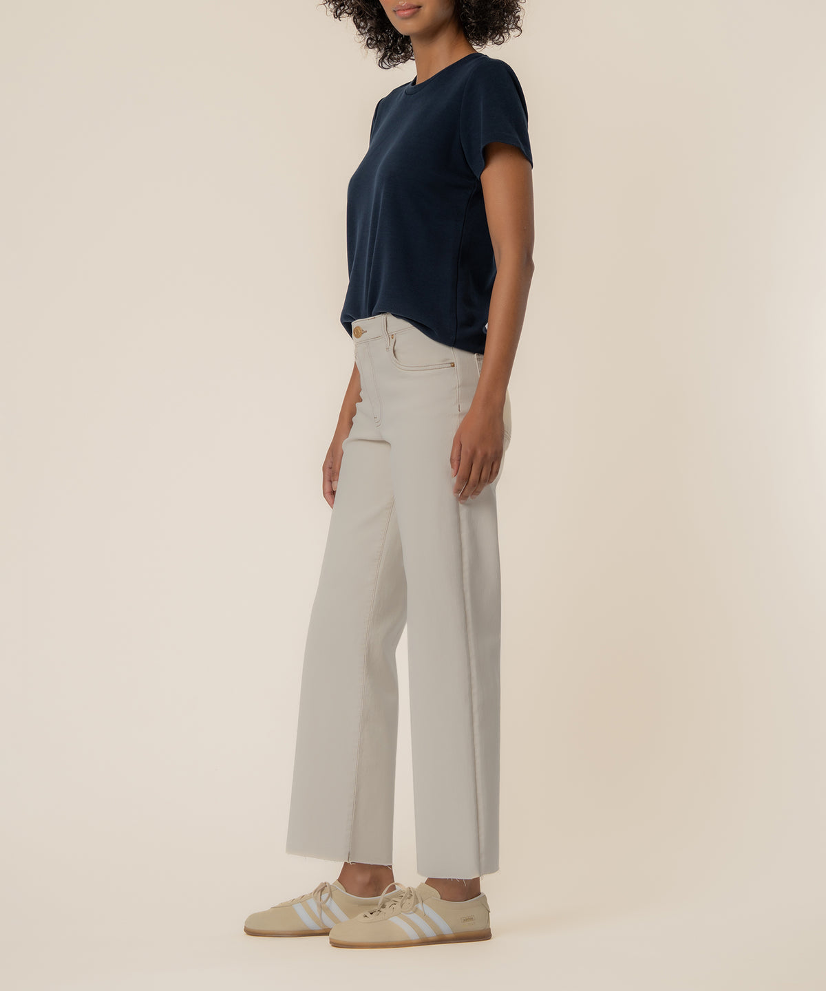 Ecru high-rise wide leg jeans with five-pocket styling, shown with navy t-shirt.
