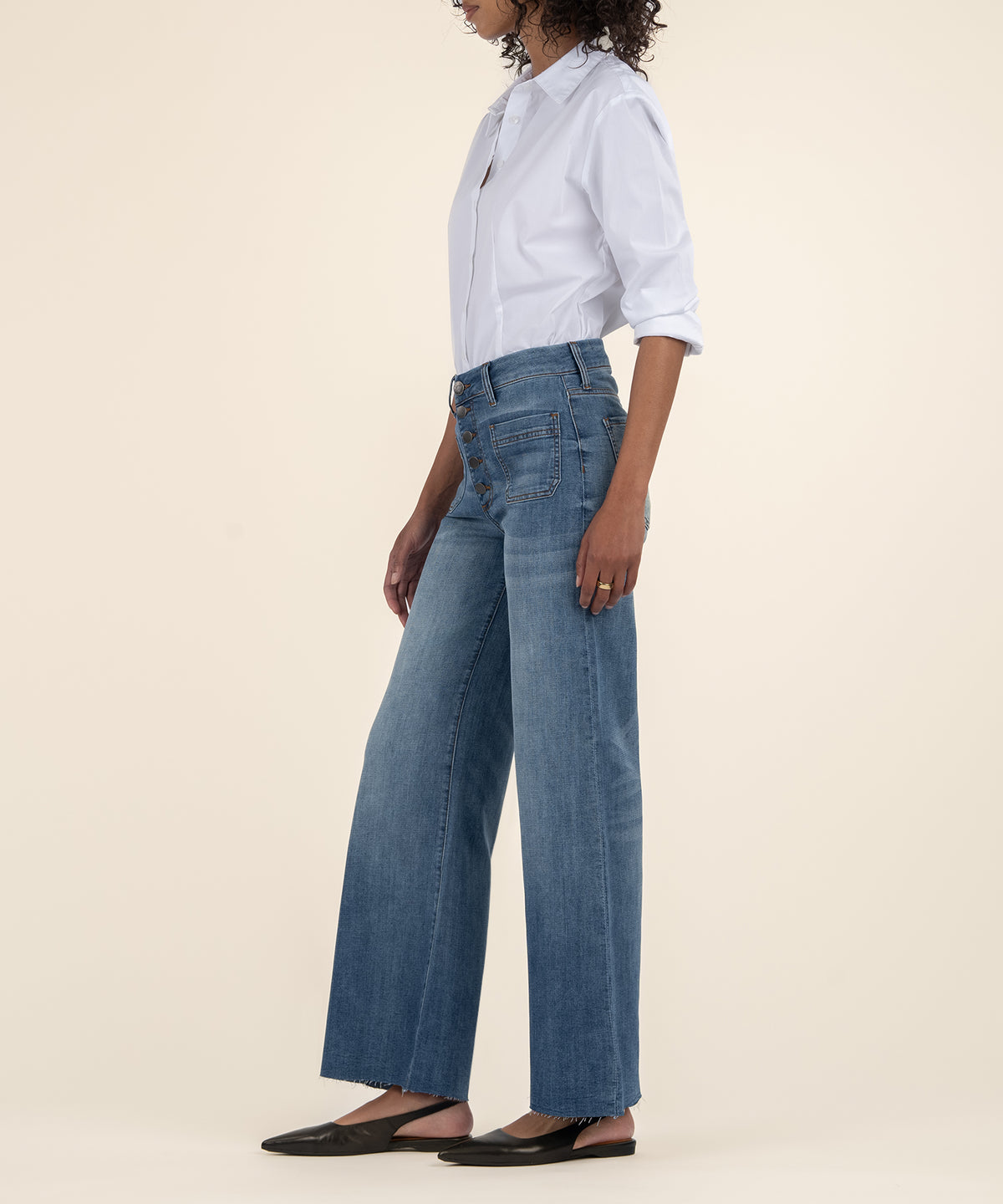 High rise, wide leg jeans in medium blue wash with long inseam, shown with white button-up shirt.