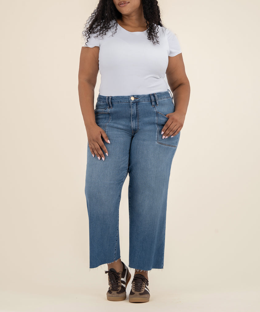 Woman wearing white short-sleeve t-shirt and blue high-rise wide-leg jeans with raw hem and front pockets.