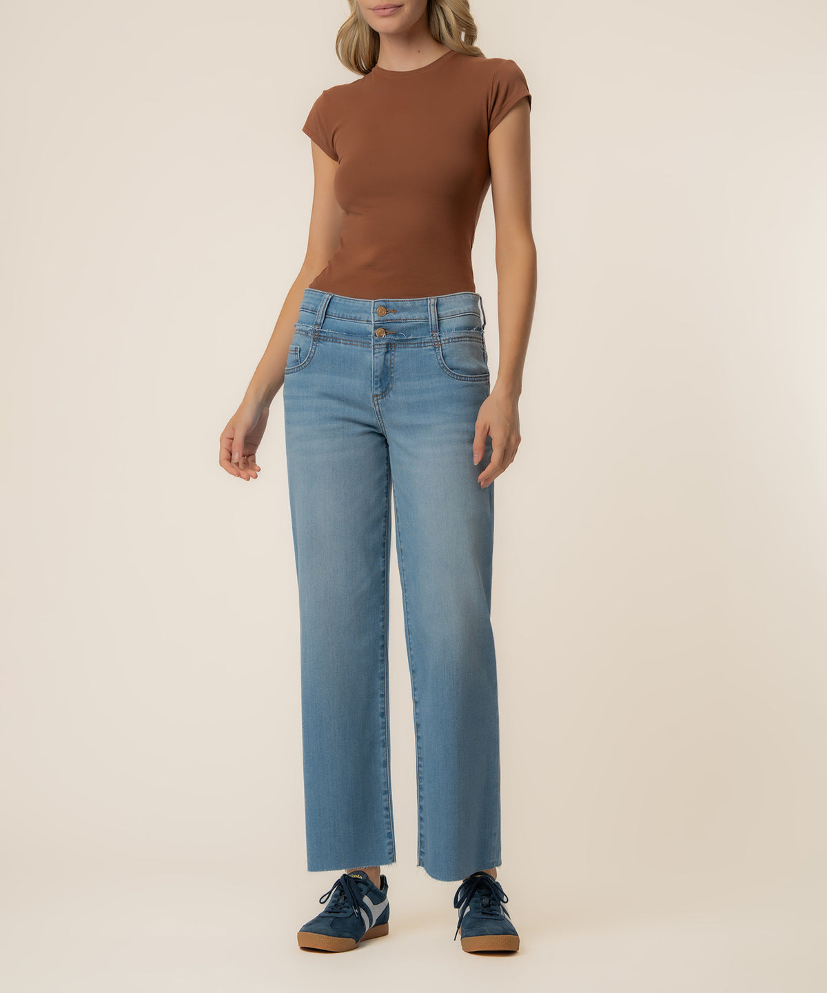 Woman wearing light blue wide-leg jeans with high rise and brown short-sleeve t-shirt.