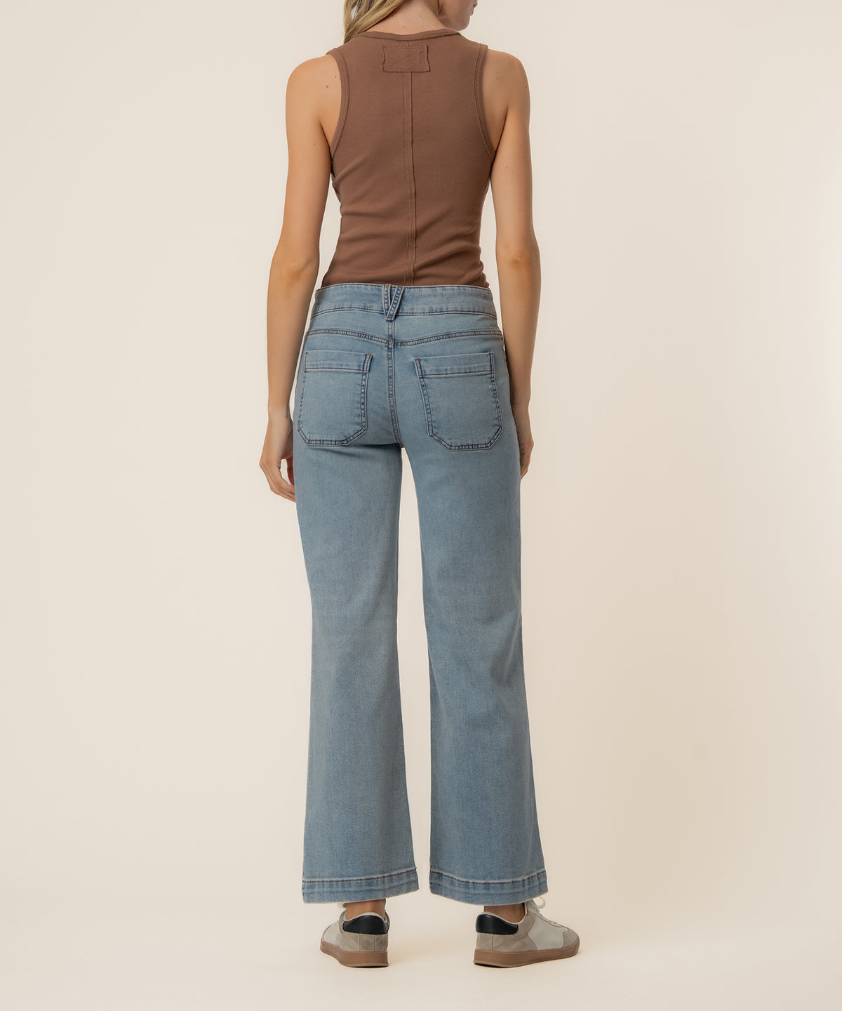 Woman wearing light blue high-rise wide-leg jeans with back pockets, shown from behind.