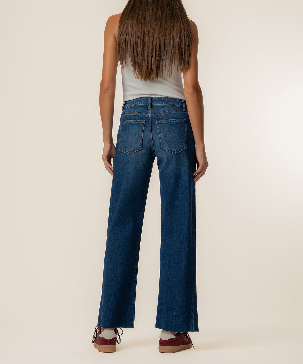 Woman wearing medium-wash wide-leg jeans with high rise and straight leg silhouette, shown from back view.