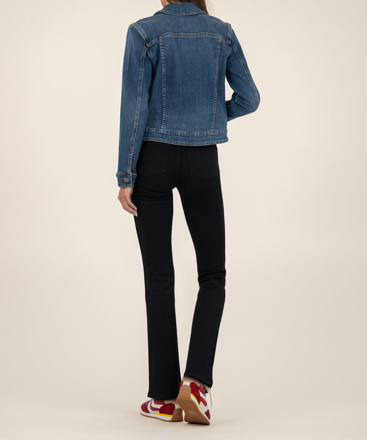 Blue denim crop jacket shown from back, worn with black pants and red and white sneakers.