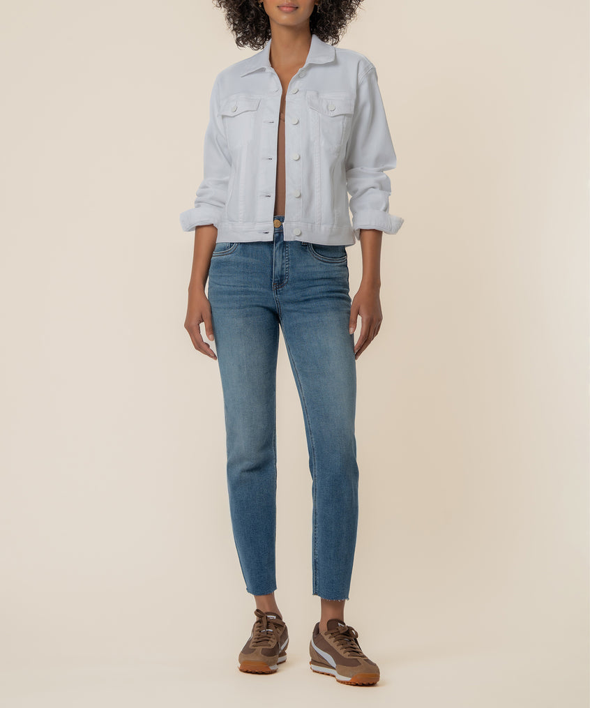 White button-front jacket with chest pockets and rolled sleeves worn over blue jeans.