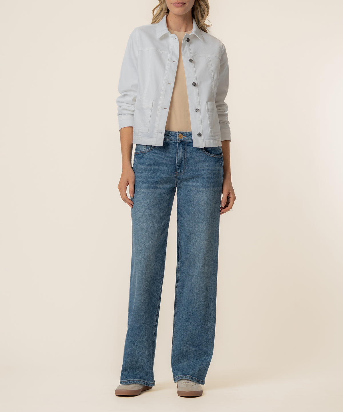 White cropped trucker jacket with button front and chest pockets, worn with blue jeans.