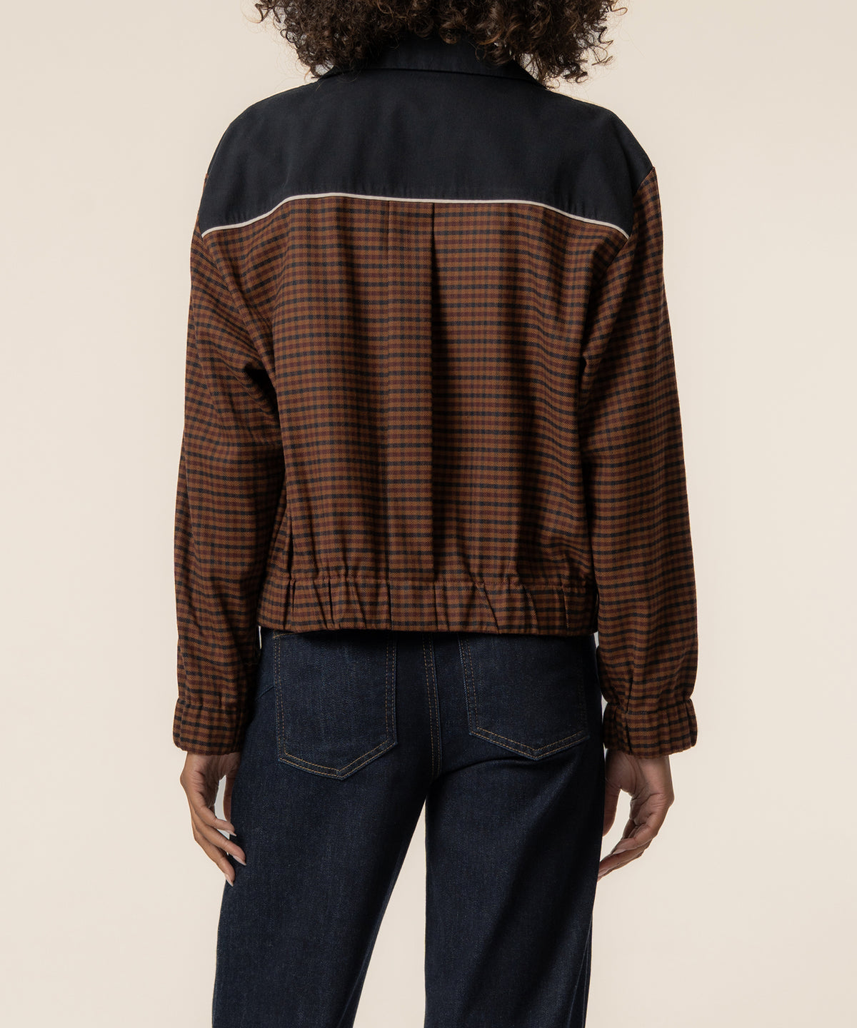 Black track jacket with brown gingham lower panels and white stripe trim, shown from back view.