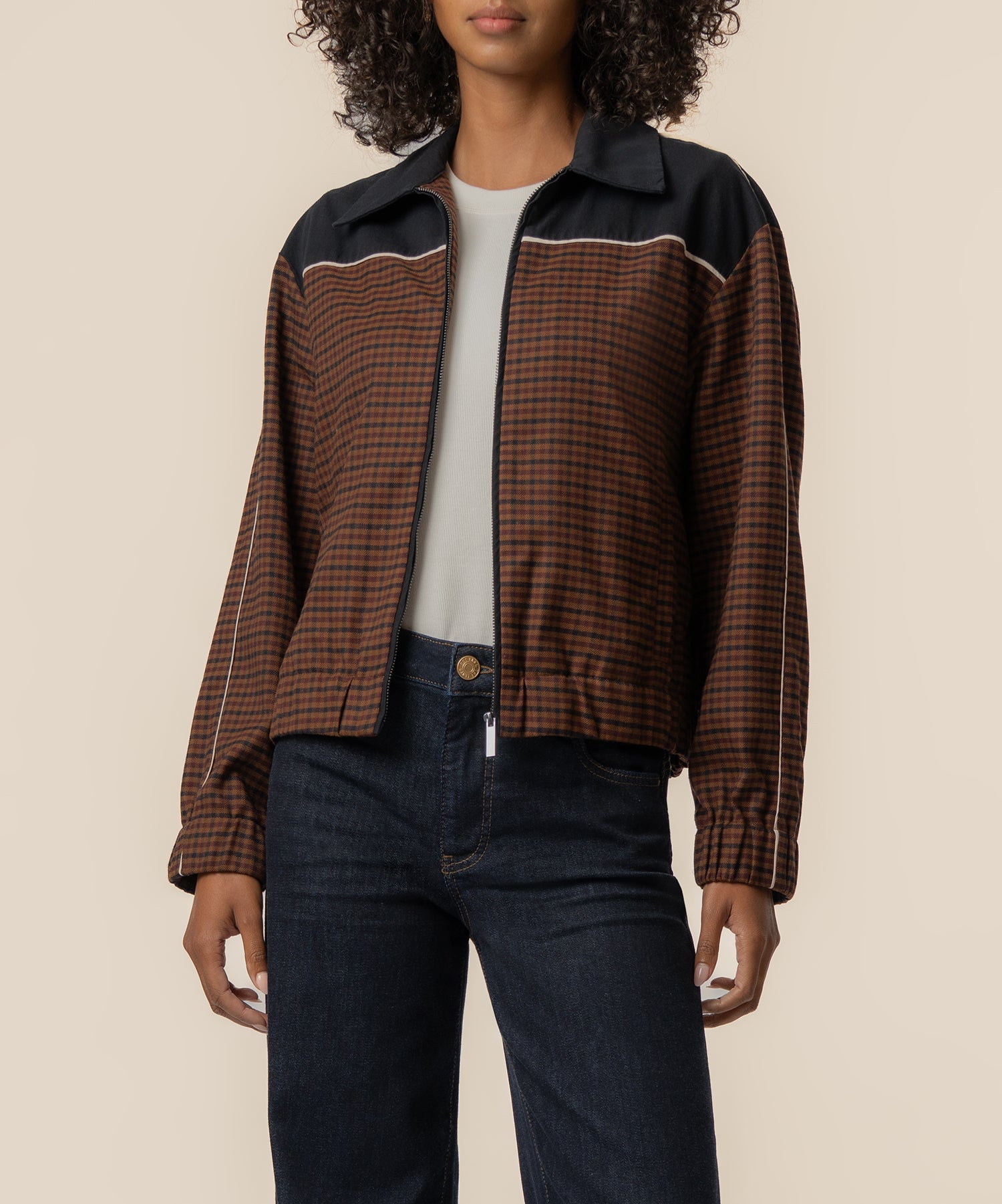 Black and brown plaid track jacket with collared neckline and white striping detail.
