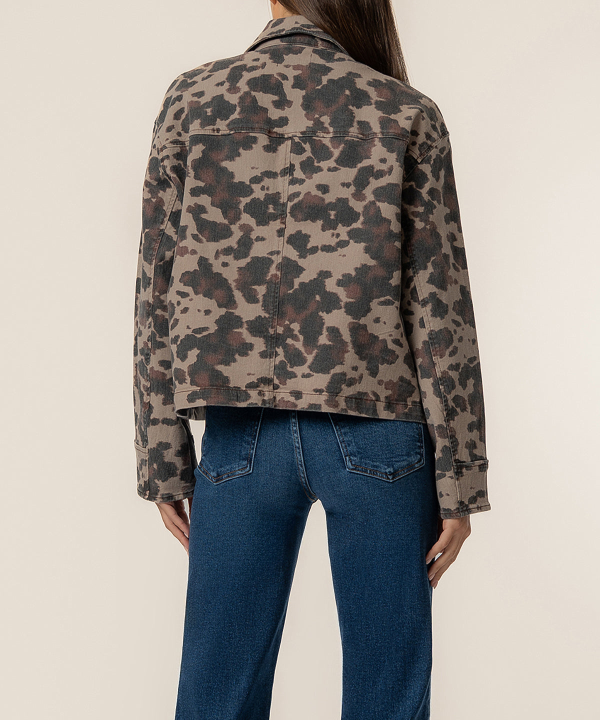 Taupe denim jacket with leopard print pattern, shown from back on model wearing blue jeans.