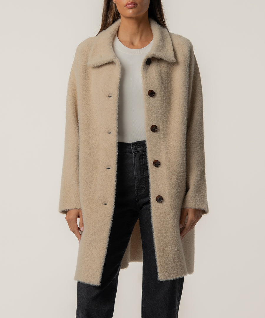 Oatmeal wool sweater jacket with notch collar and button front, worn over white tee and black jeans.