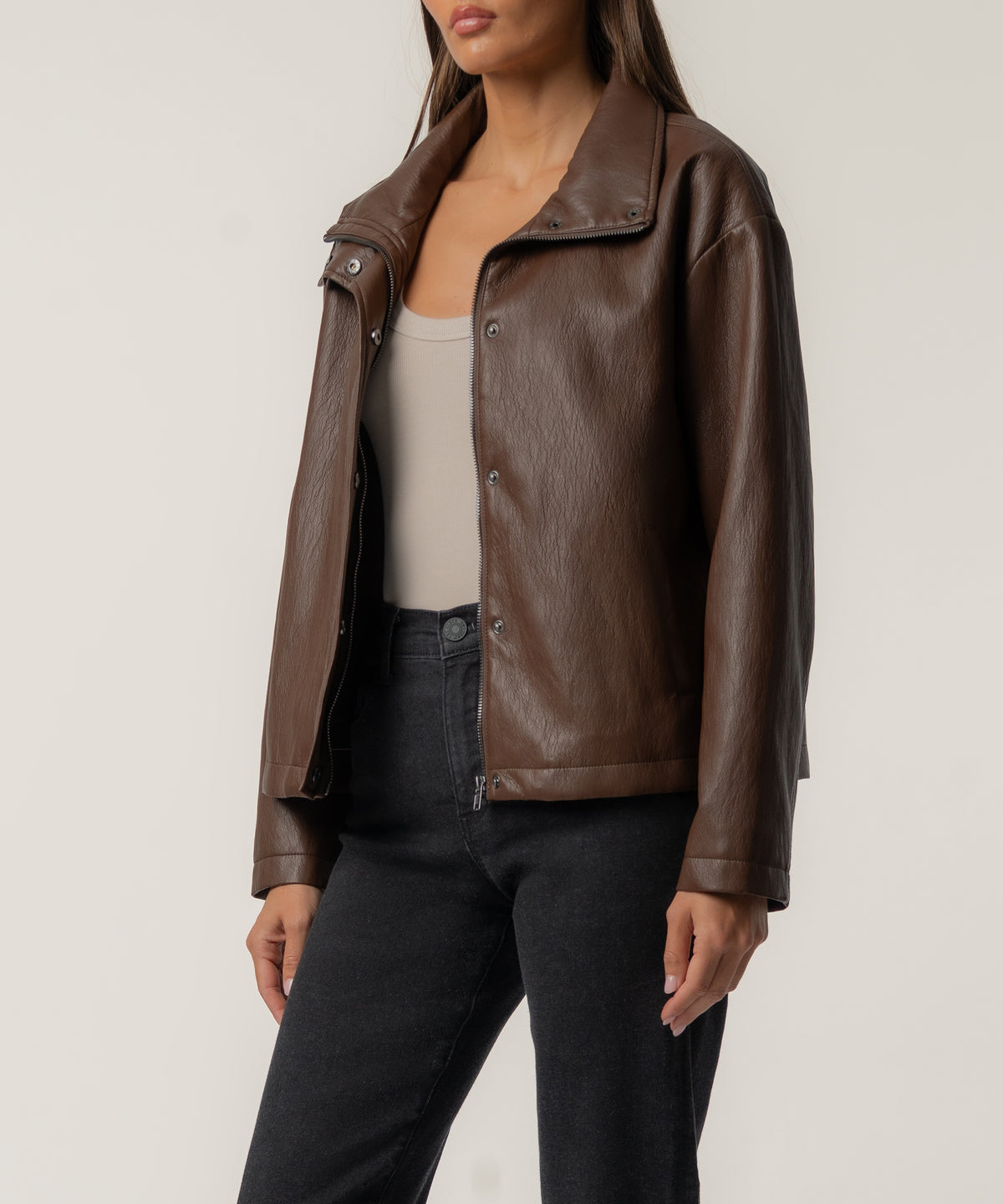 Brown leather jacket with spread collar, snap button front closure, and ribbed cuffs.